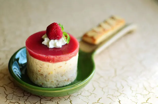 Entremets individuel à la framboise présenté sur une assiette